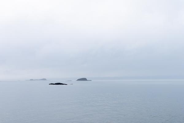 The islands of Fidra and the Lamb loom out of the mist on a still, silvery sea